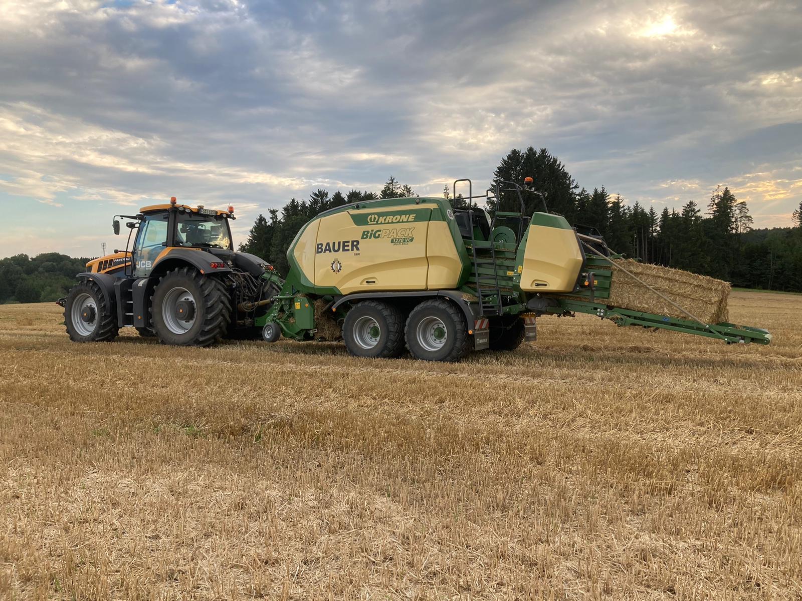 Bauer-Quaderballenpresse auf einem abgeernteten Feld im Abendlicht